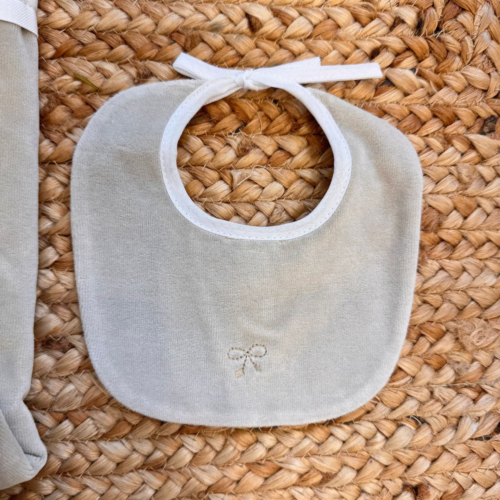 Bavetta in ciniglia beige con ricamo fiocchetto.