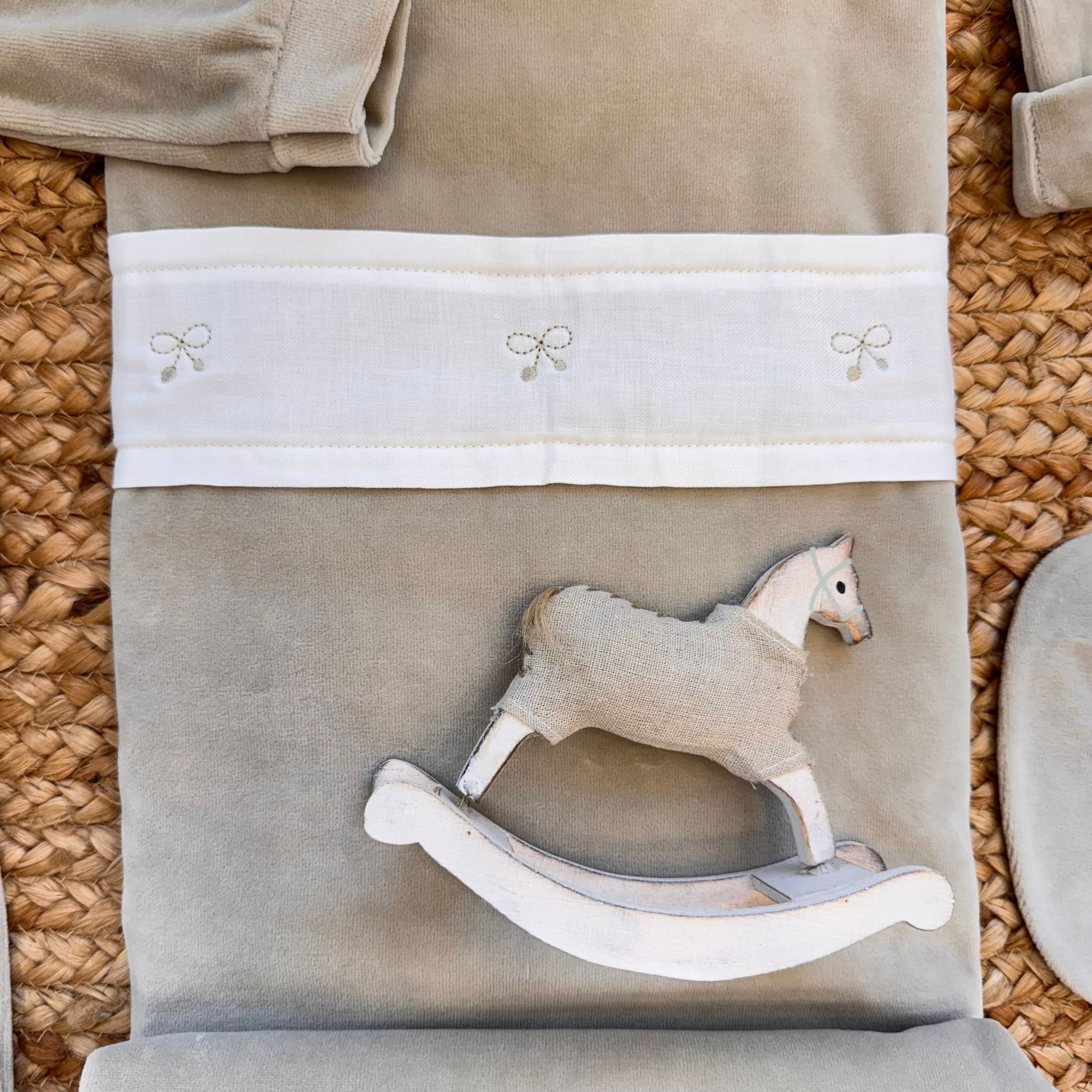 Coperta beige con fascia bianca e ricami tono su tono.