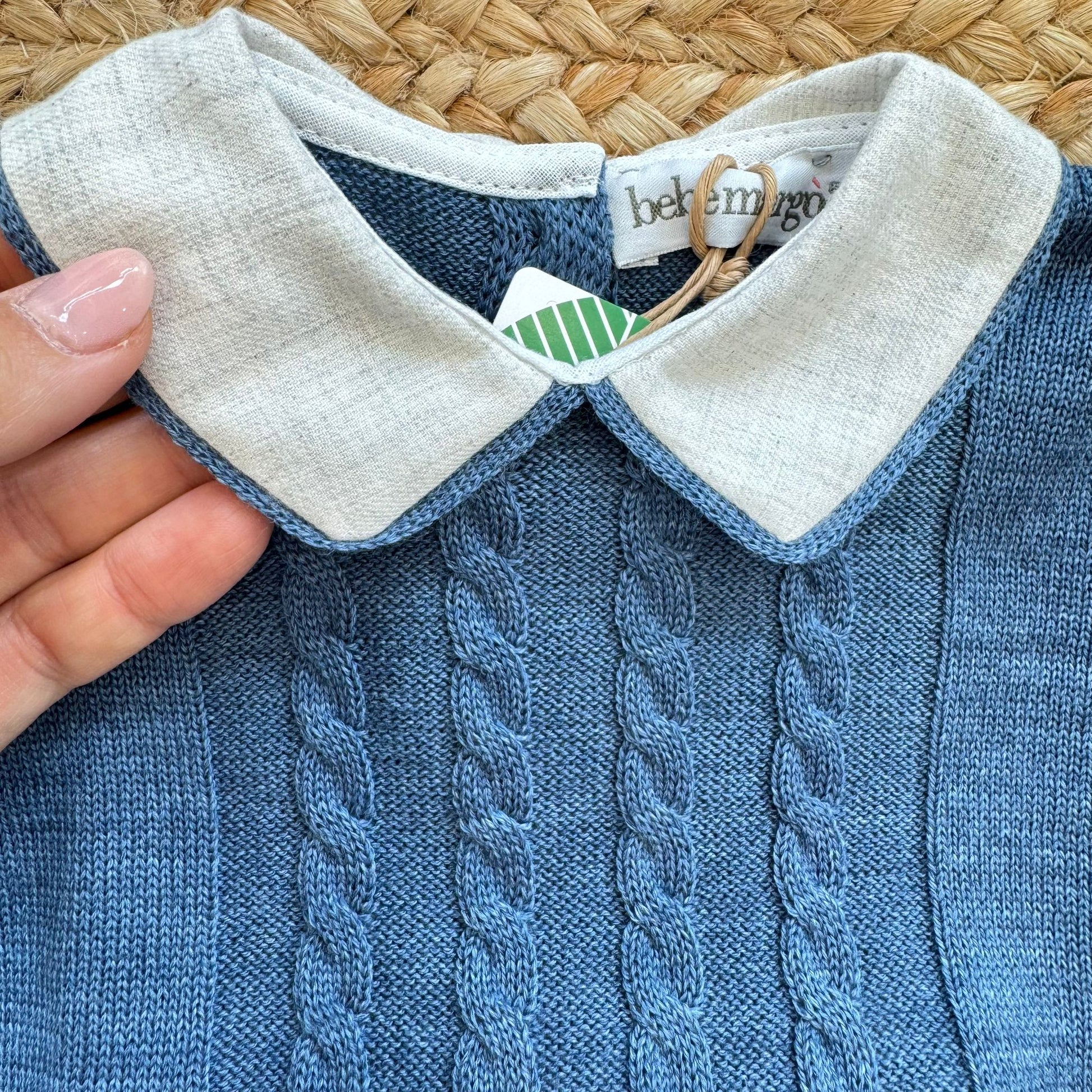 Dettaglio colletto bianco sulla maglia blu con lavorazione a trecce