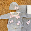 Dettaglio tutina con fiocchetti e collettino rosa