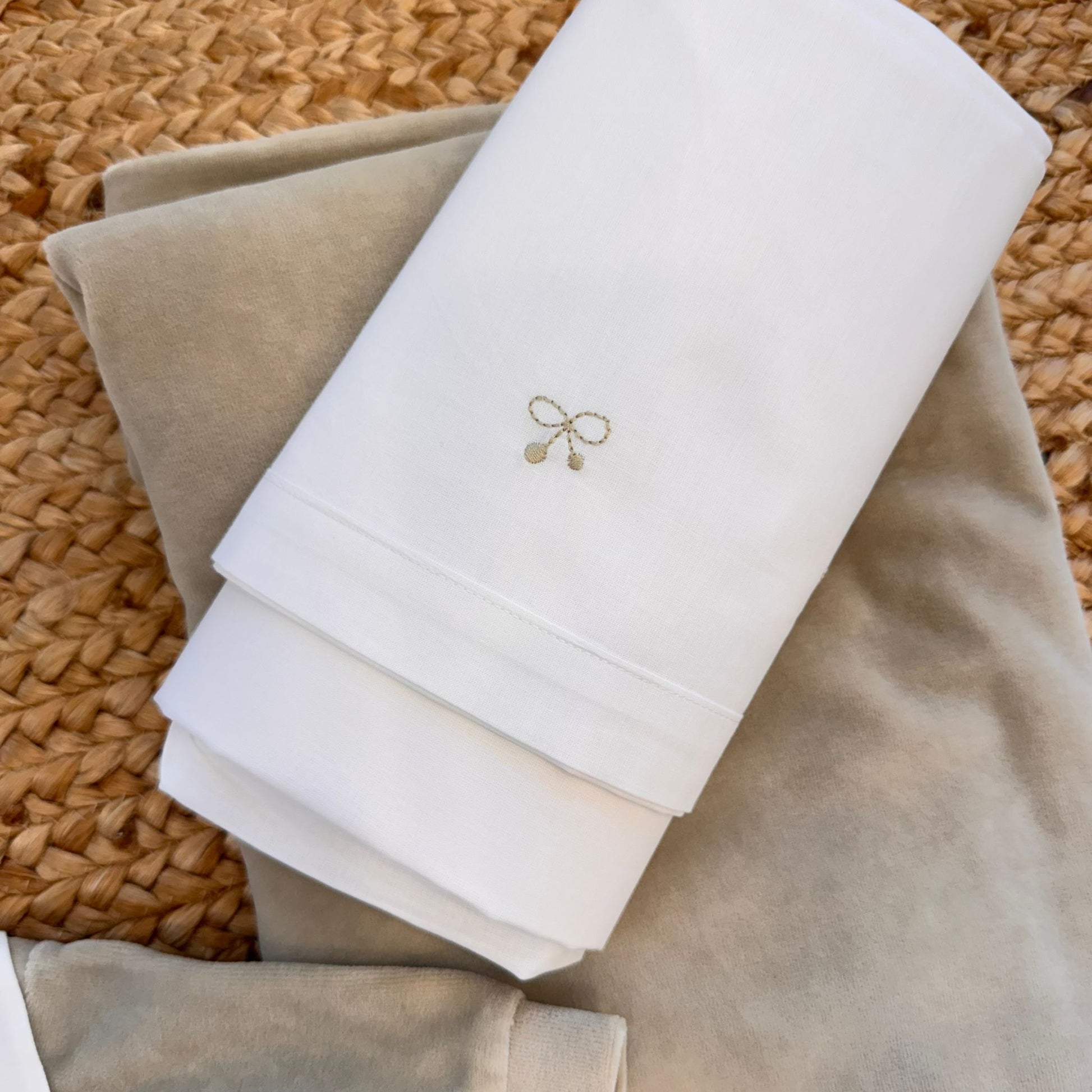 Lenzuola bianche con ricamo fiocchetto beige.