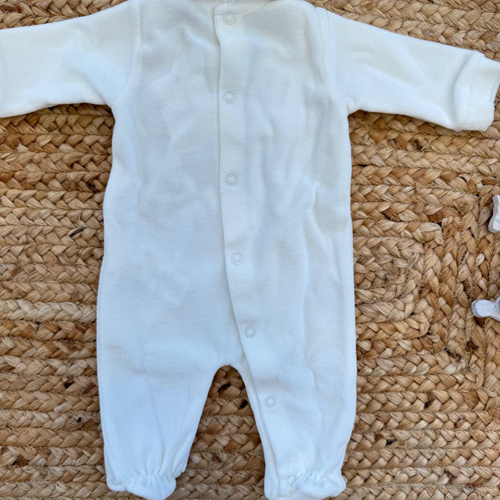 Retro della tutina in ciniglia bianca con apertura a bottoncini a pressione.