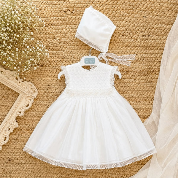 Abito Battesimo bimba bianco con ricamo nido d'ape, punto smock e cuffietta coordinata.