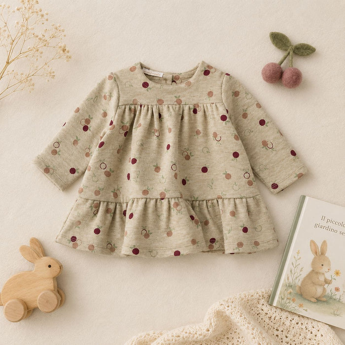 Bimba con abito beige a manica lunga con fantasia di piccoli frutti e balza sul fondo