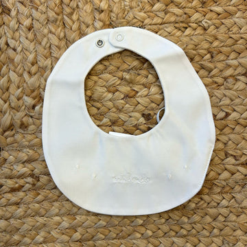 Bavaglino neonato panna con ricamo bianco “ninnanda” e chiusura a clip.