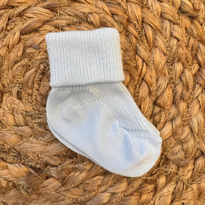 Calzina azzurra per neonato in caldo cotone con risvolto alto.