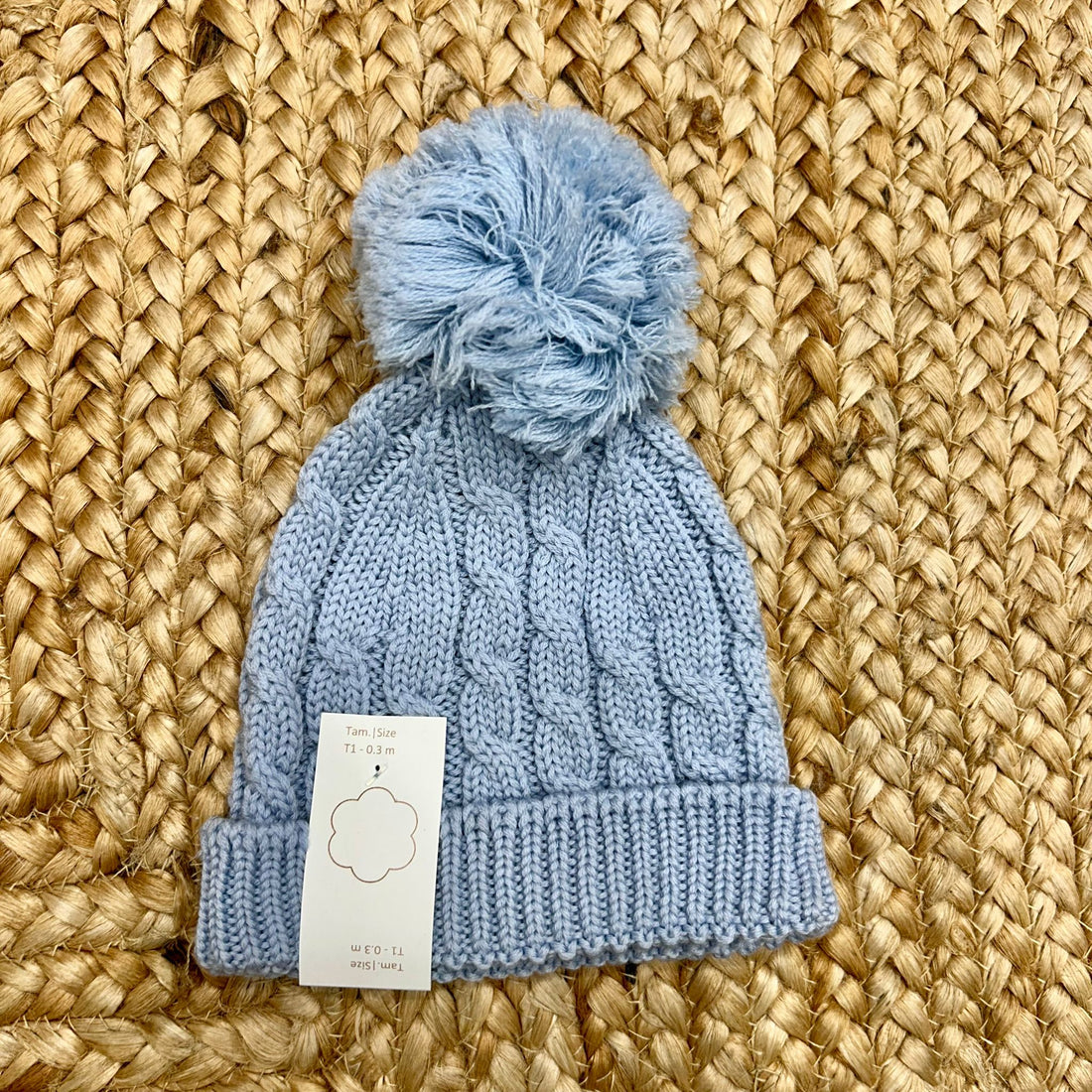 cappellino azzurro in maglia intrecciata con grande pompon per neonato