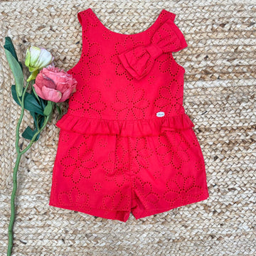 Romper rosso per bambina in cotone sangallo con fiocco decorativo e balza in vita, ideale per l'estate.