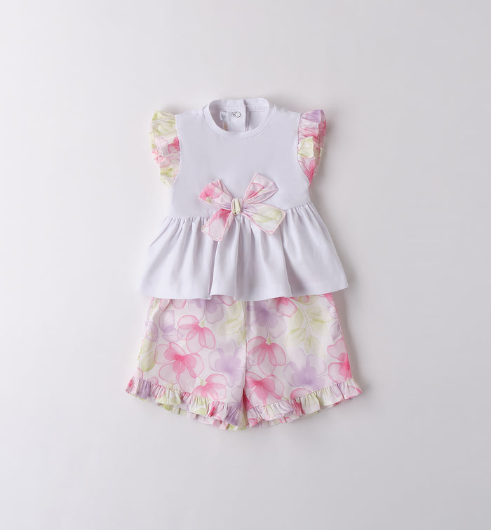 Completo bambina in cotone con top bianco e shorts floreali con balze.