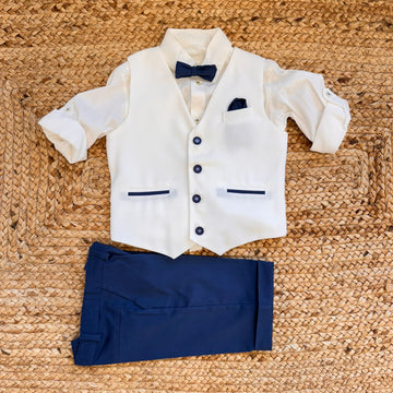 Completo elegante bambino con gilet panna, camicia, papillon blu e pantaloni blu navy per cerimonia.