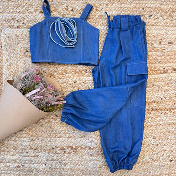 Completo chambray bambina con top e pantaloni cargo su fondo naturale