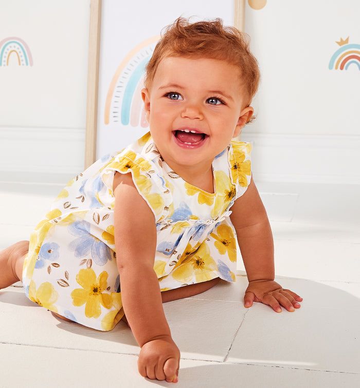 Completo estivo per bambina con fantasia floreale gialla e blu, perfetto per la stagione calda.