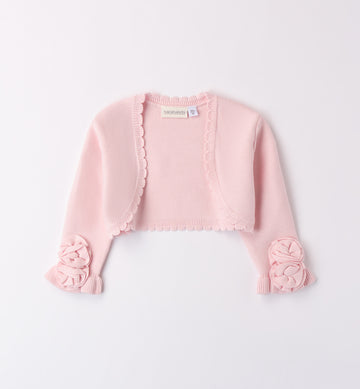 Coprispalle rosa cipria in maglia per bambina con dettagli floreali e bordo smerlato.