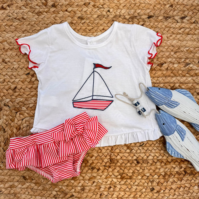 Costume slip a righe rosse con fiocco e t-shirt con stampa barchetta per bambina.