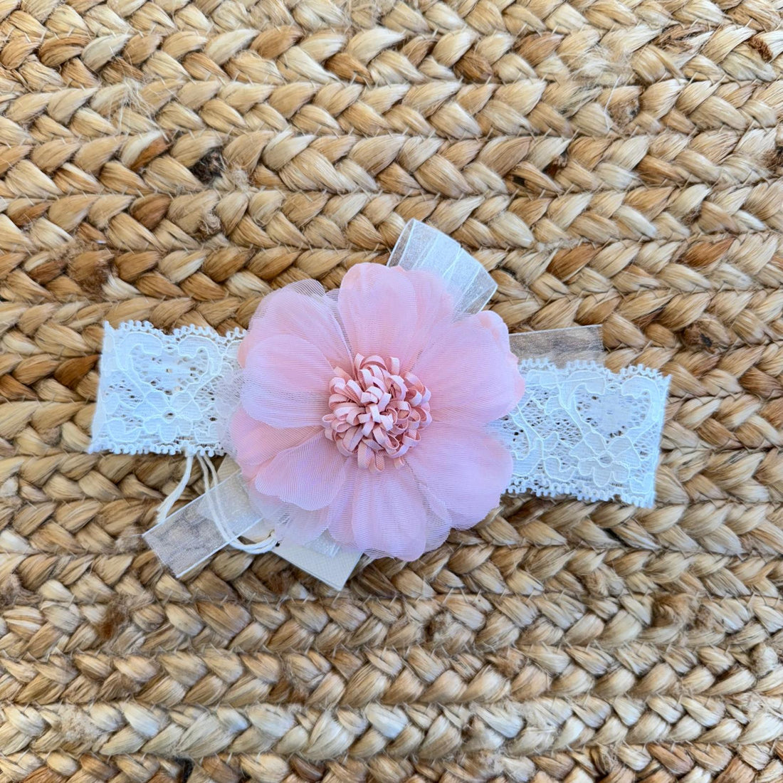 Fascia battesimale bianca in pizzo con fiore rosa in organza, ideale per neonate e cerimonie eleganti.