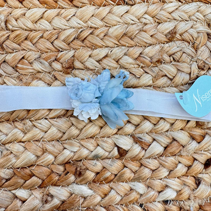 Dettaglio fascia cerimonia bimba con applicazione floreale azzurro polvere