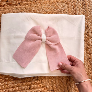 Lenzuolino in cotone panna per neonata con maxi fiocco rosa in maglia, ideale per corredino autunno inverno
