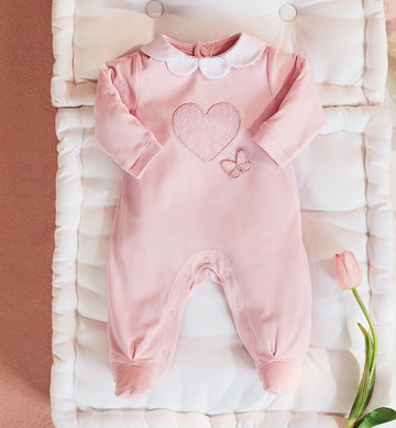 Delicata tutina in cotone rosa con ricamo cuore e farfalla, perfetta per i primi giorni della tua bambina. Realizzata in 100% cotone Made in Italy, garantisce morbidezza e comfort sulla pelle delicata del neonato. Il colletto in piqué bianco aggiunge un tocco di raffinatezza, mentre la chiusura con bottoncini a pressione sul retro e sul cavallo facilita il cambio.
Ideale per l’uscita clinica, le prime coccole a casa e le occasioni speciali.
