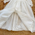 Abito battesimo bimba lungo bianco con punto smock, pizzo floreale e cuffietta coordinata
