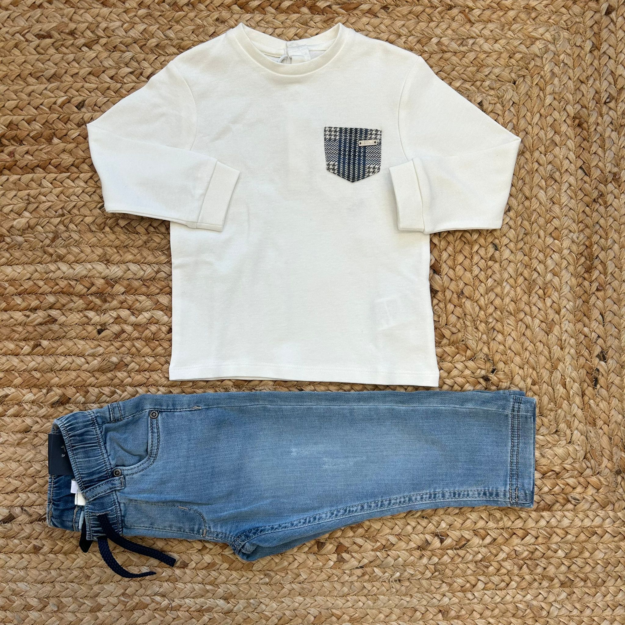 Maglia bimbo panna con taschino fantasia e jeans chiaro