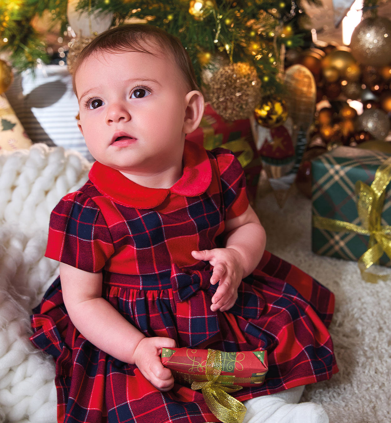 Abito natalizio per neonata in tessuto scozzese rosso e blu con fiocco e colletto in velluto, perfetto per le feste di Natale.