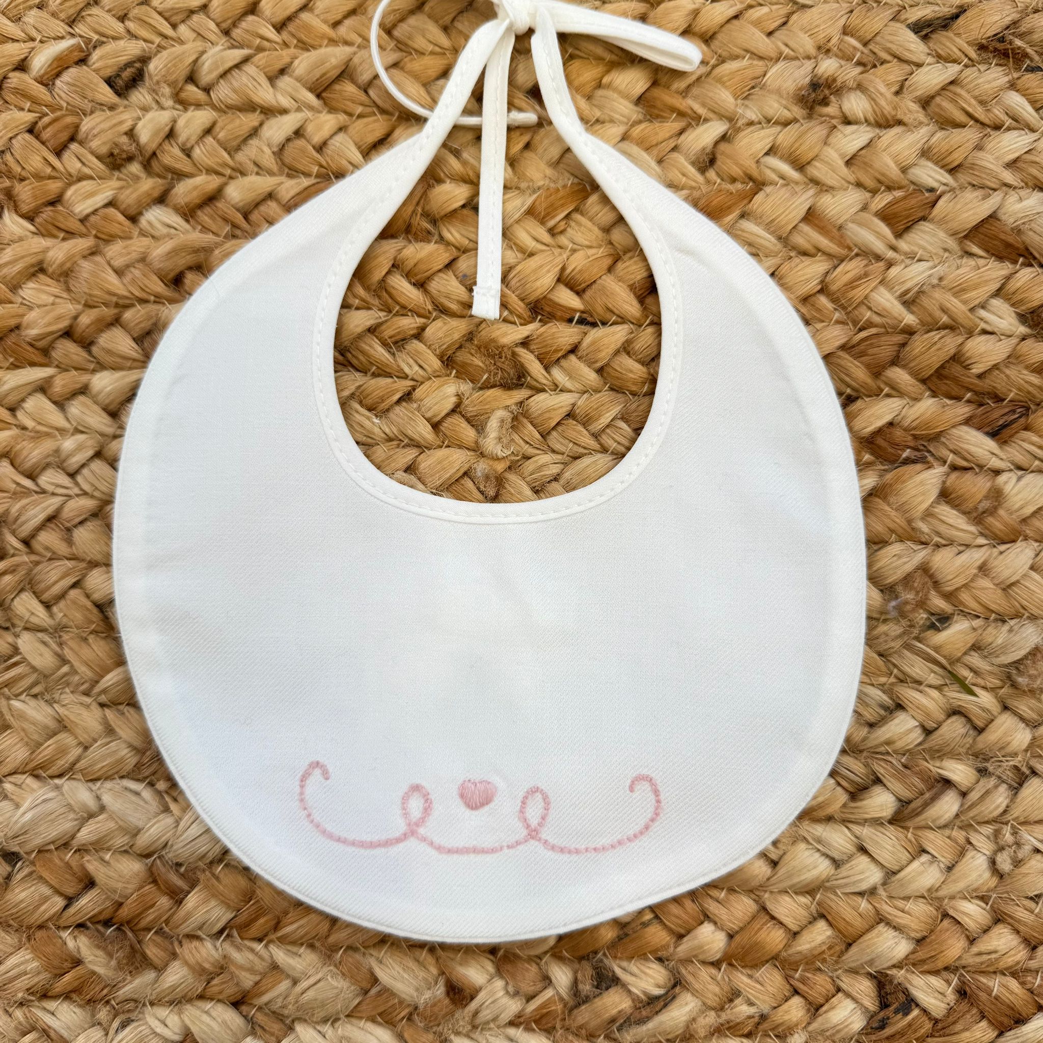 Bavaglino neonata bianco con ricamo rosa a cuore e riccioli