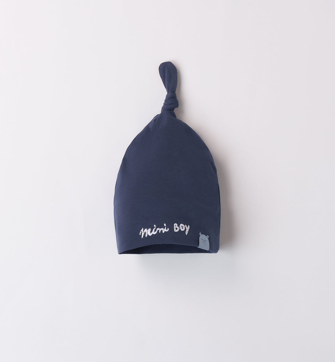 Cappellino neonato in cotone blu con nodo sulla punta e ricamo "Mini Boy". Morbido, elasticizzato e ideale per l’uscita clinica e il corredino nascita.