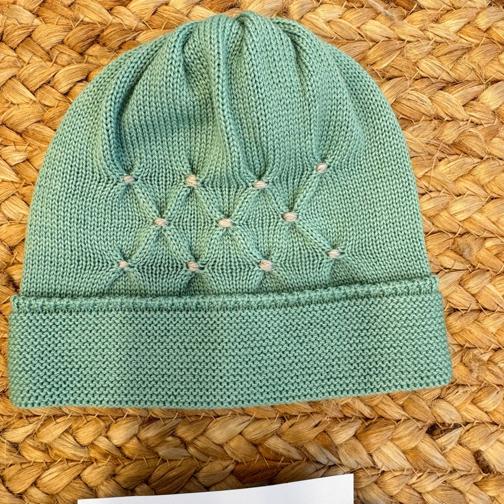 Cappellino verde foglia per neonato in pura lana con ricamo a nido d’ape e punto nodino – parte del set nascita