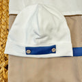 Cappellino in cotone con applicazioni in tessuto, perfettamente abbinato alla tutina per un look armonioso e sofisticato.

