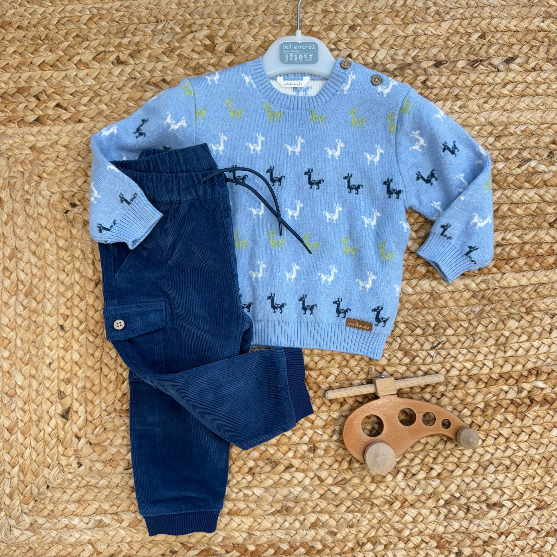 Completo casual chic bimbo con maglia azzurra fantasia dinosauri e pantaloni blu in velluto.