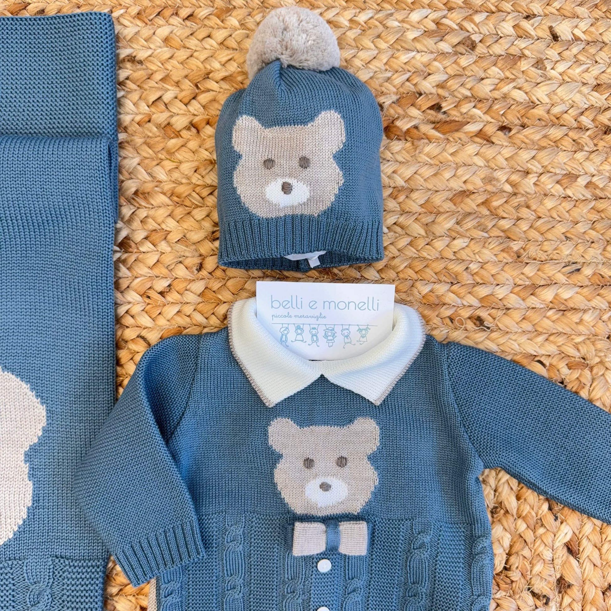 Coordinato neonato verde ottanio e sabbia in pura lana con orsetto ricamato, composto da tutina due pezzi, cappellino, scarpette e copertina.