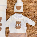 Coordinato uscita clinica con orsetto beige e fiocco panna, completo di copertina, coprifasce, cappellino e scarpette.