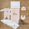Coordinato uscita clinica neonata rosa con cuori e fiocchetto.