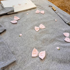 Coperta grigia con fiocchi e roselline ricamate