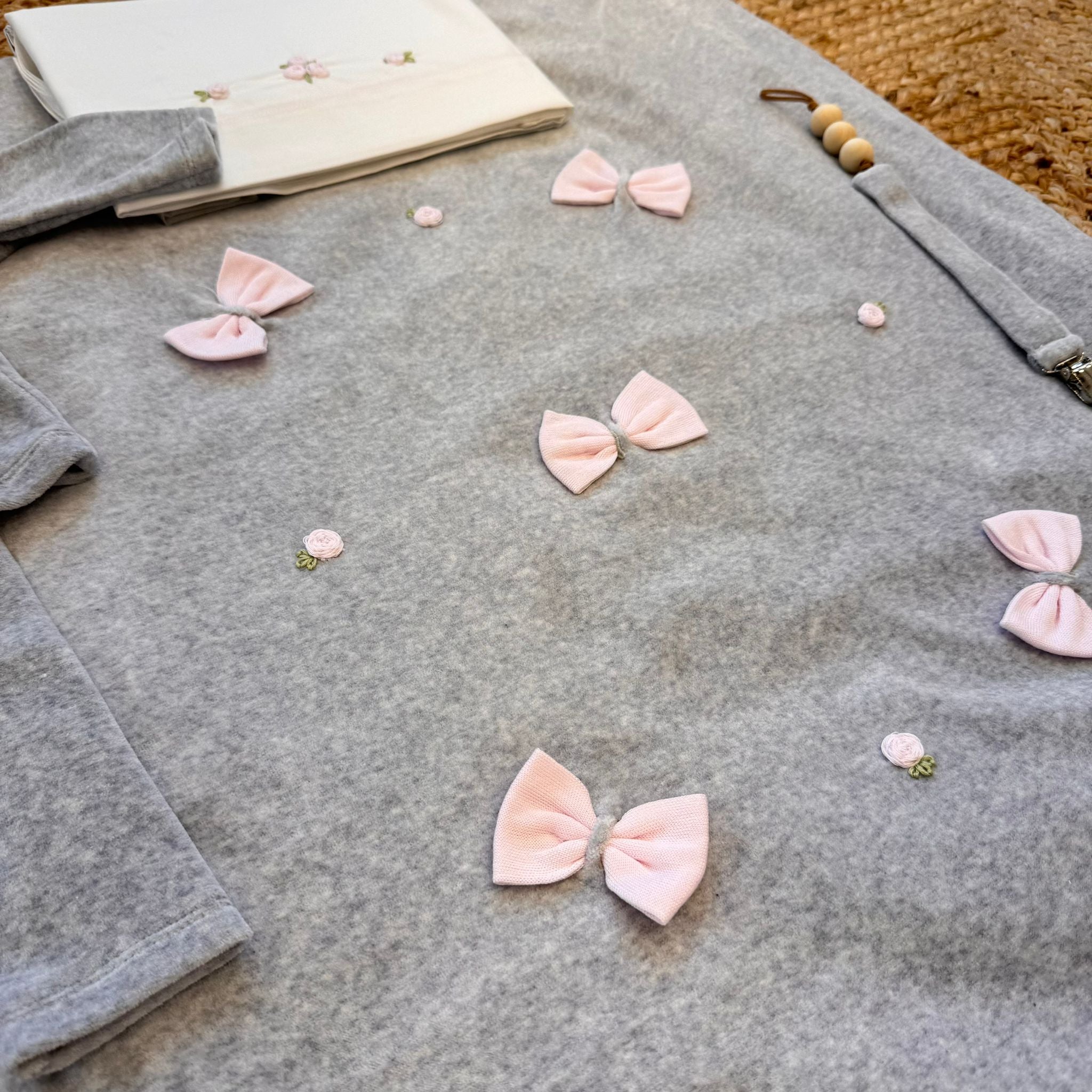 Coperta grigia con fiocchi e roselline ricamate