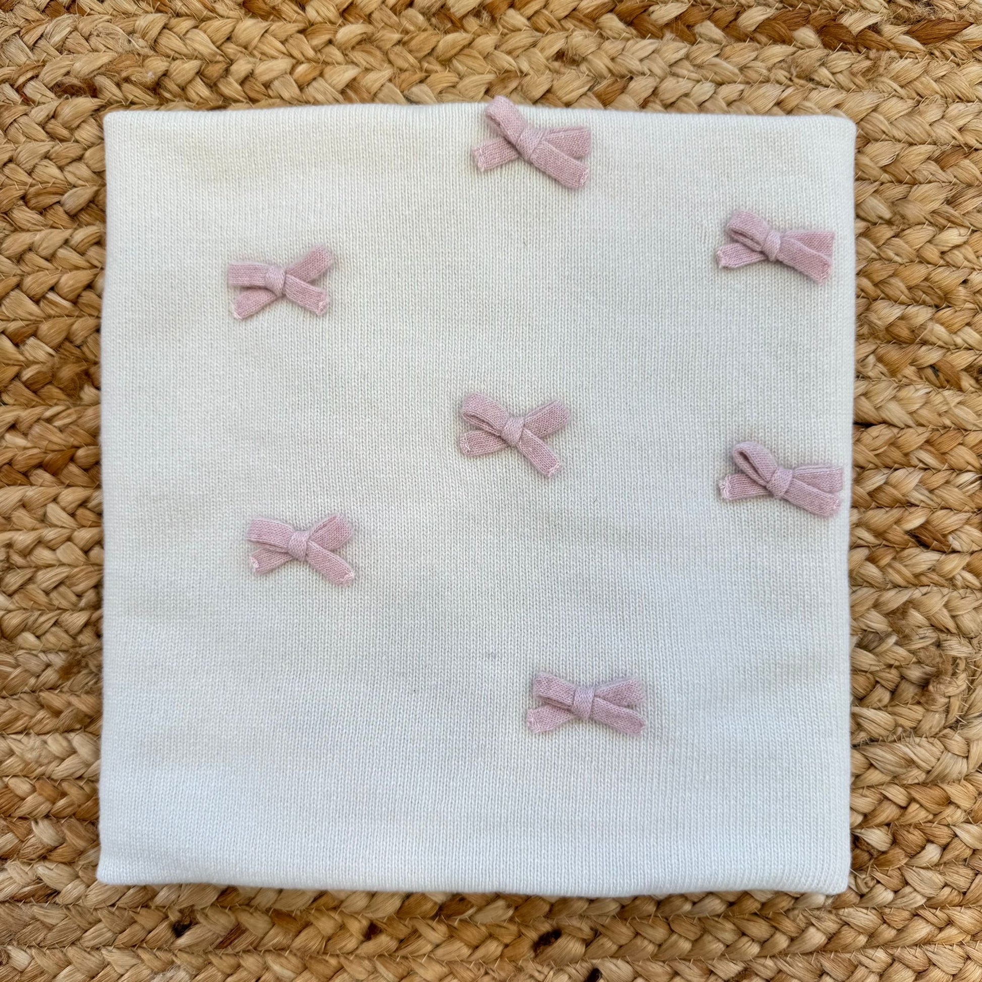 Copertina neonata in pura lana panna con fiocchetti rosa applicati