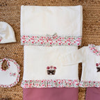 Copertina neonato in caldo cotone con bordo floreale e fiocco coordinato.