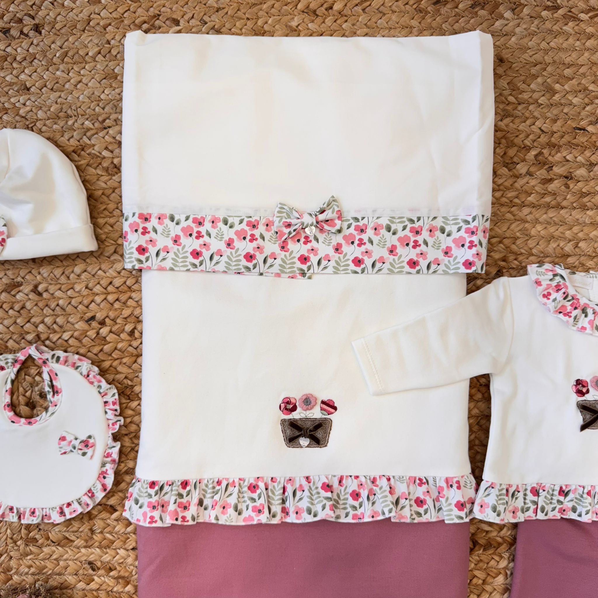 Copertina neonato in caldo cotone con bordo floreale e fiocco coordinato.