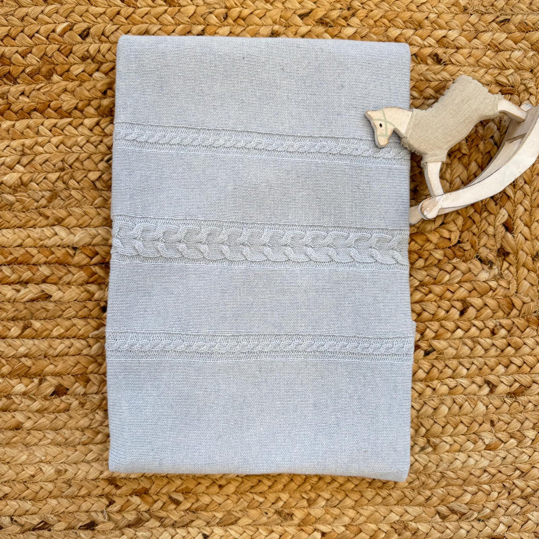 Copertina neonato in lana e cashmere con lavorazione intreccio a trecce tono su tono.