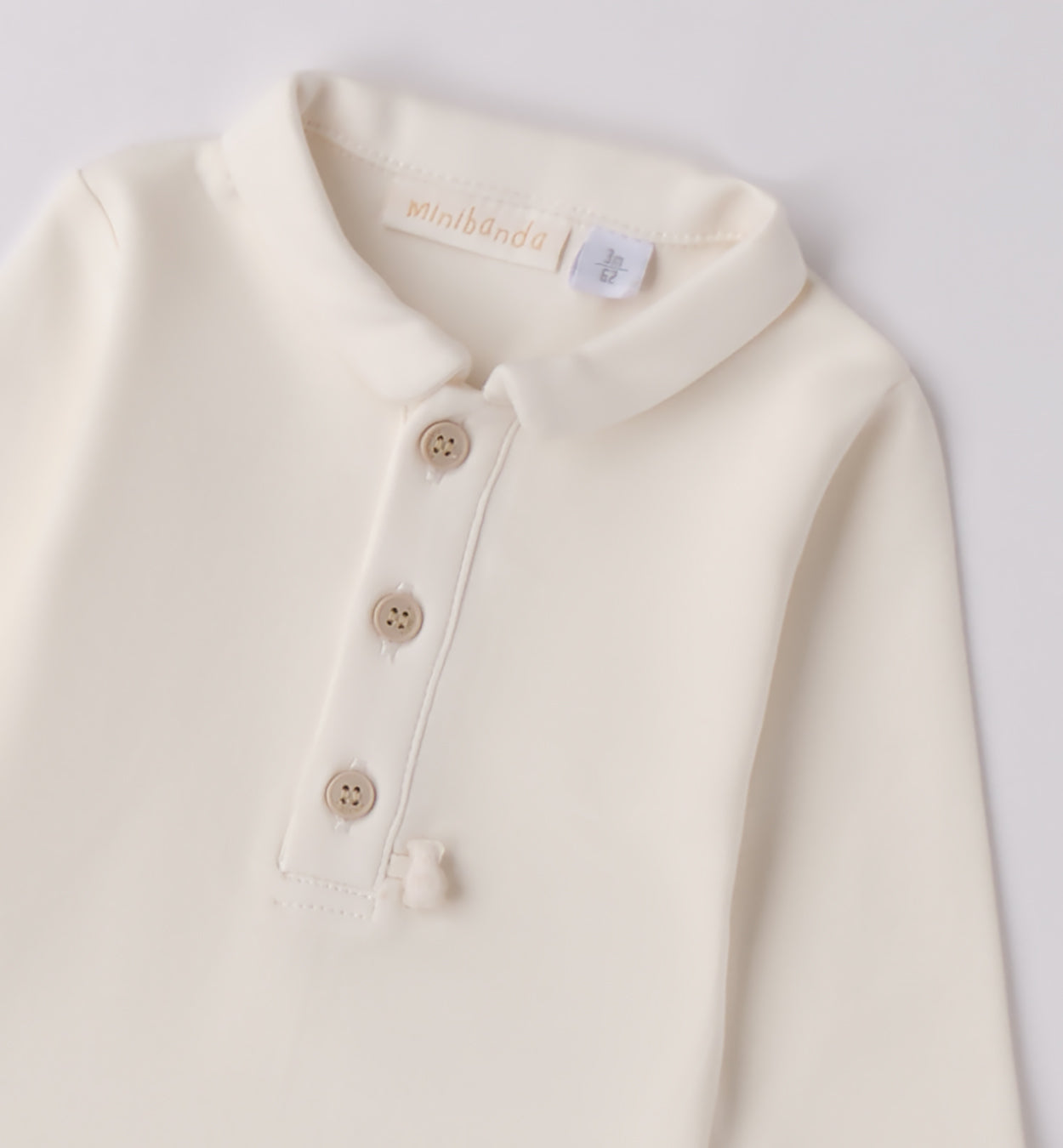 Dettaglio bottoncini body panna neonato