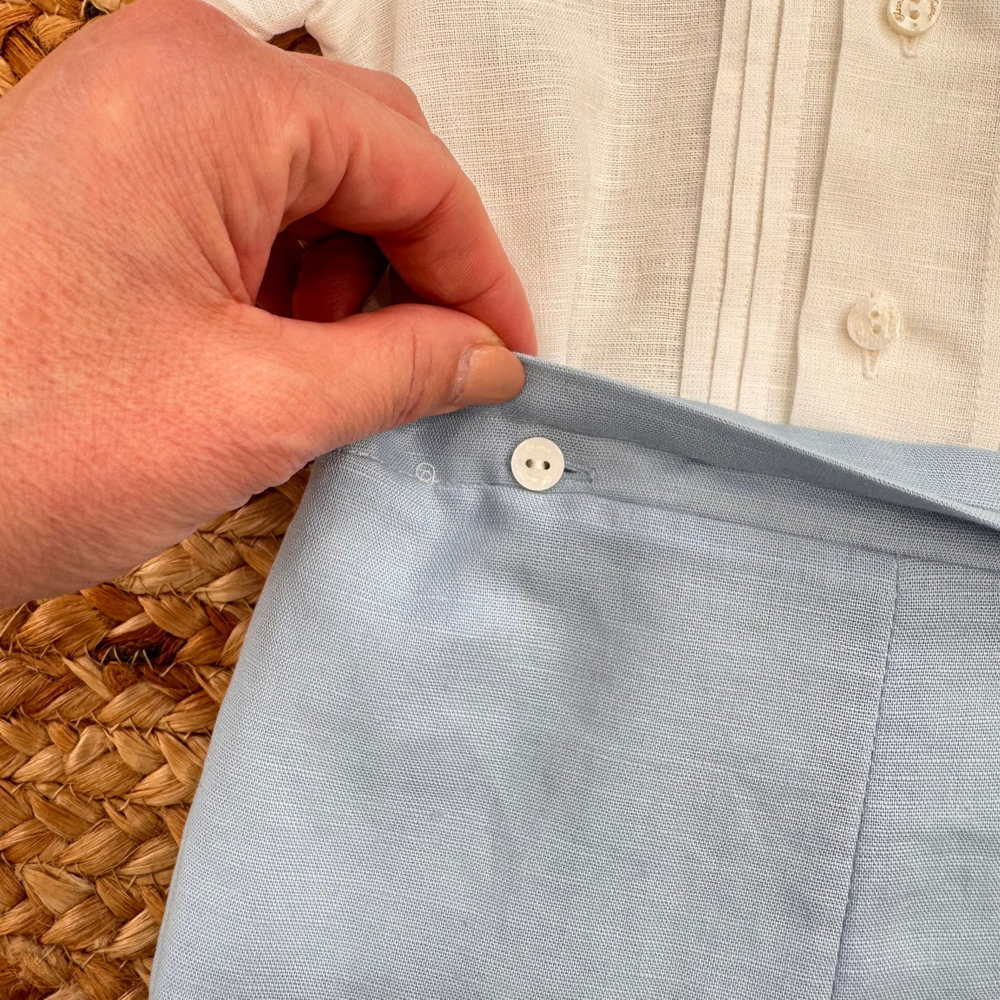 Dettaglio bottone laterale pantaloncino celeste completo battesimo bimbo