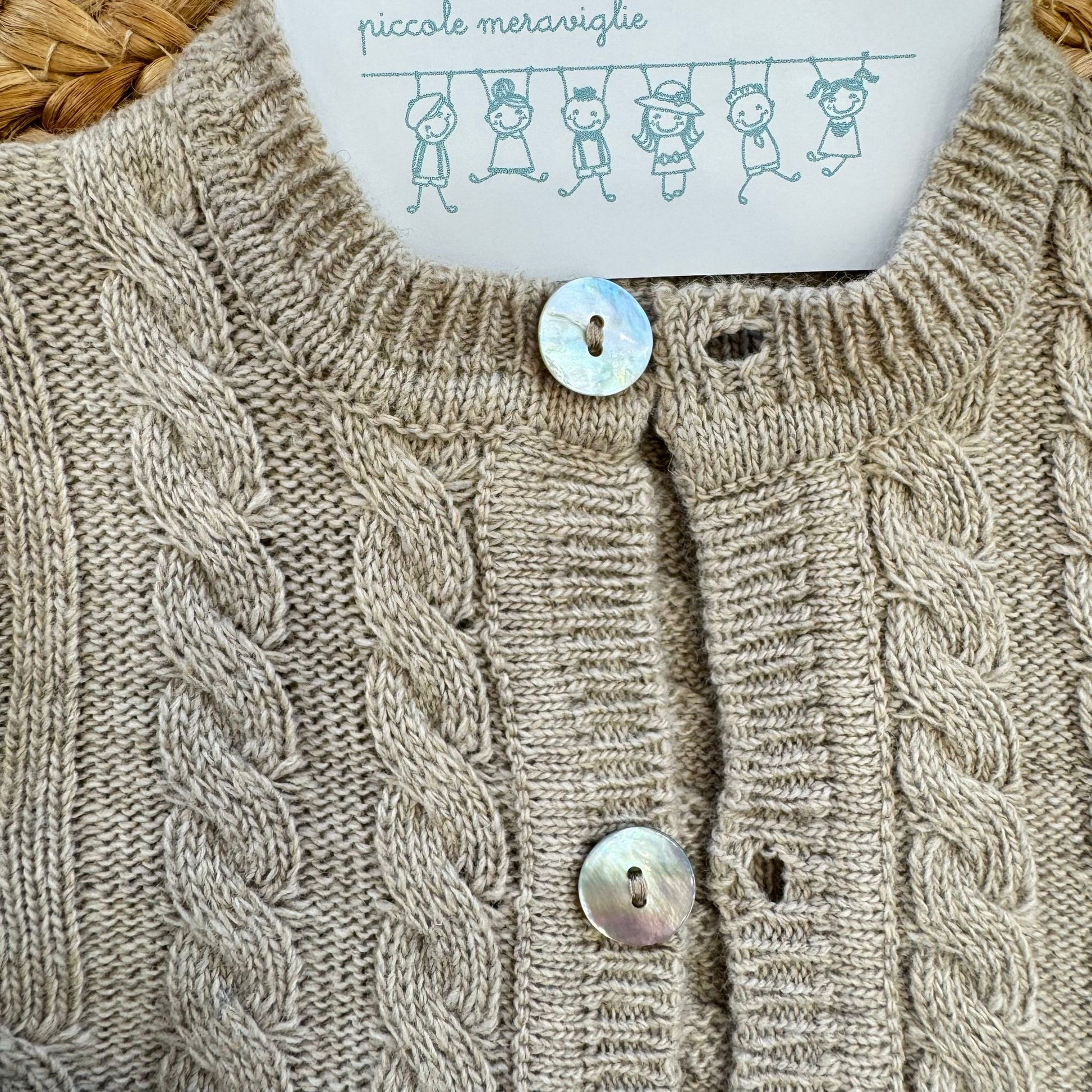 Dettaglio bottoni madreperla cardigan neonato beige