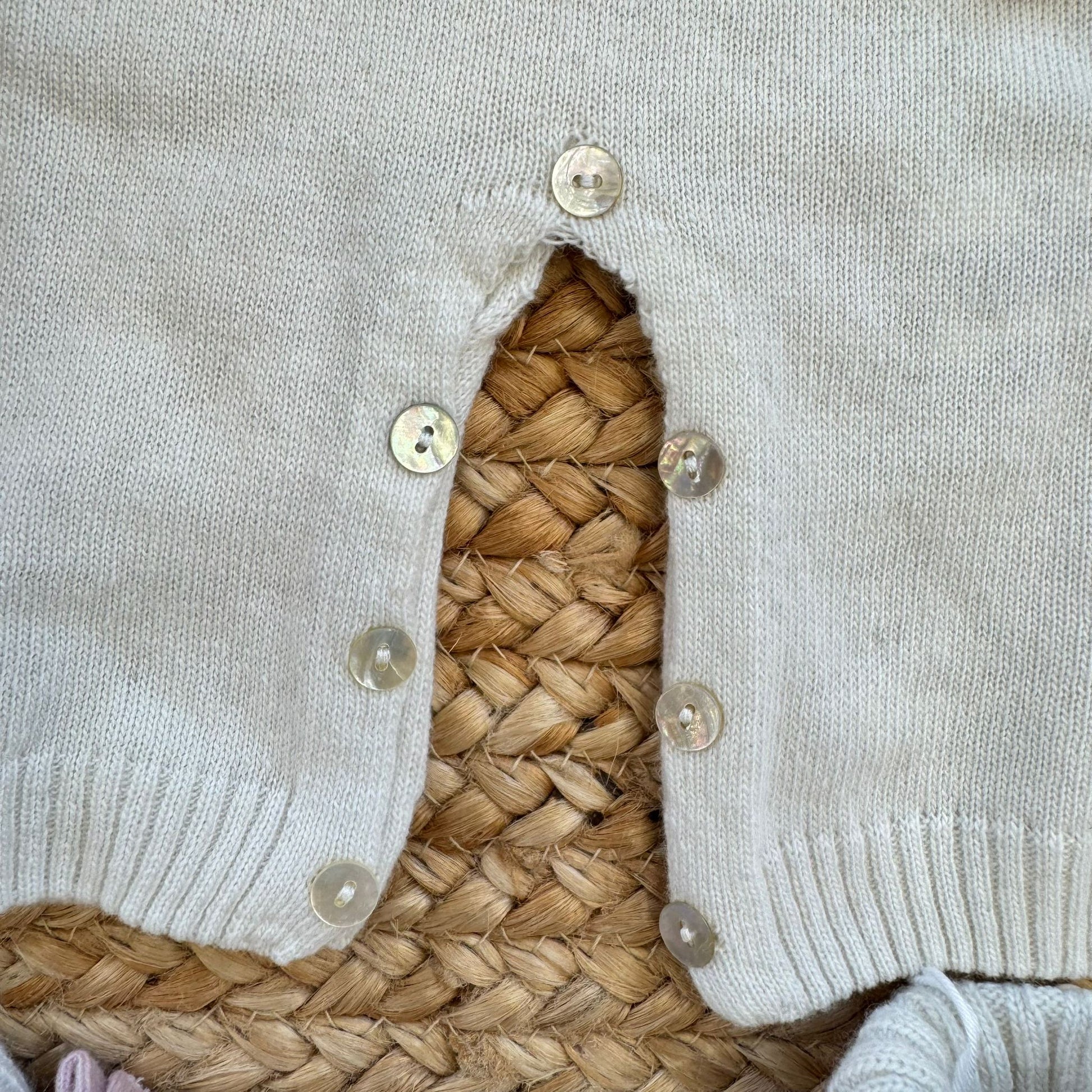 Dettaglio bottoni madreperla tutina neonata panna con fiocchi rosa