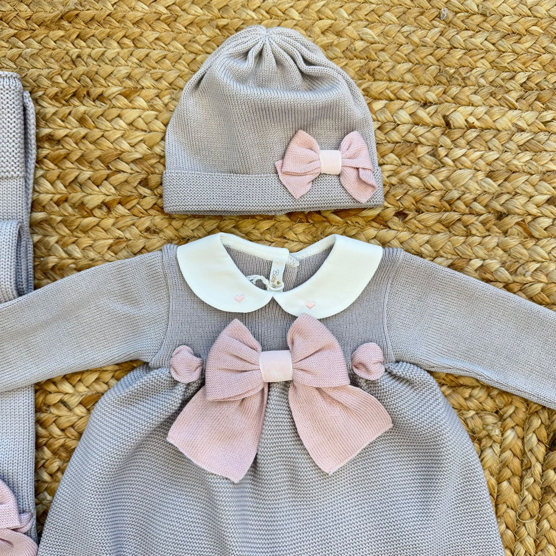 Dettaglio cappellino neonata grigio con fiocco rosa coordinato