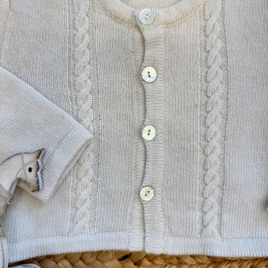 Cardigan neonato panna con trecce sottili e bottoni madreperla