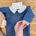 Dettaglio colletto bianco e manica con polsino beige della tutina neonato