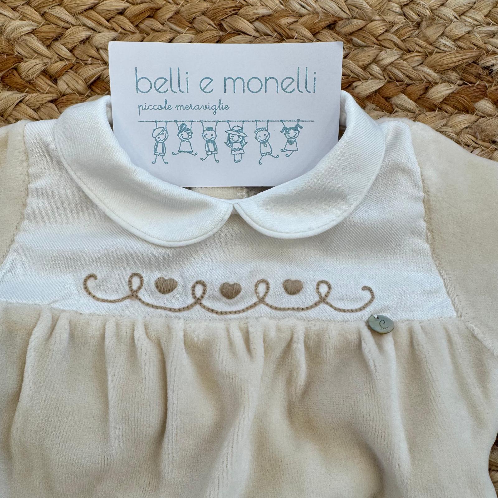 Dettaglio colletto bianco e ricamo cuori della tutina neonata in ciniglia panna.