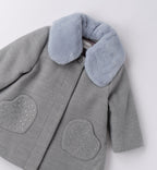 Dettaglio collo in pelliccia e tasche a cuore con strass