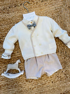 Dettaglio completo con papillon scozzese e bordo beige cardigan