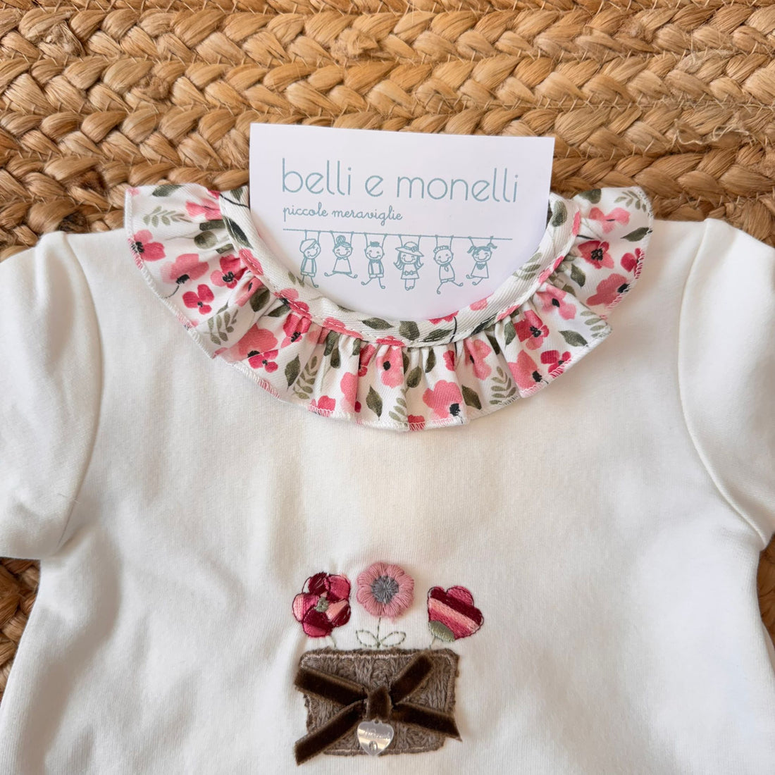 Coordinato due pezzi per neonata in caldo cotone floreale, composto da maglia e pantalone con piedini.
